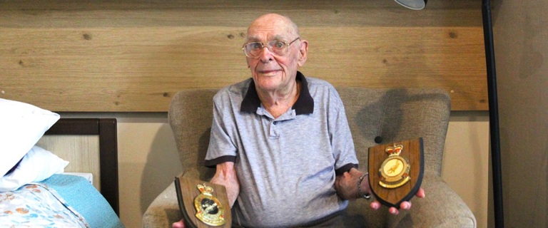 Lewis with his awarded service plaques.jpg Lewis with his awarded service plaques.jpg